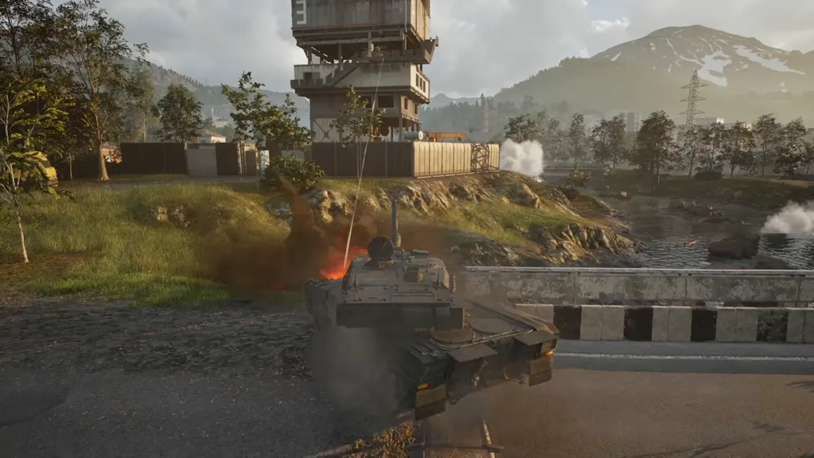 A WARDOGS armoured vehicle advancing along a road with infantry nearby